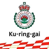 The official logo of the NSW Rural Fire Service Ku-ring-gai district featuring a crown, flames, and red and white checkered emergency markings.